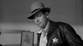 Movie still from “Paper Moon” (1973), directed by Peter Bogdanovich – A black and white photo of a man wearing a hat; Close Up shot, Low angle