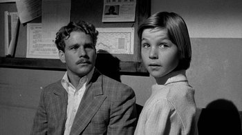 Movie still from “Paper Moon” (1973), directed by Peter Bogdanovich – A man and a woman standing next to each other; Close Up shot, Over the shoulder angle