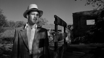 Movie still from “Paper Moon” (1973), directed by Peter Bogdanovich – A black and white photo of a man wearing a suit and a hat; Medium shot, Low angle
