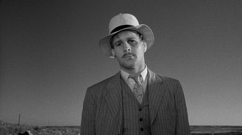 Movie still from “Paper Moon” (1973), directed by Peter Bogdanovich – A black and white photo of a man wearing a suit and a hat; Close Up shot, Low angle