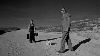 Movie still from “Paper Moon” (1973), directed by Peter Bogdanovich – A man and a woman standing in the desert; Wide shot, Low angle