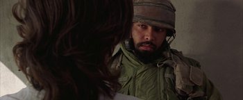 Movie still from “Paradise Now” (2005), directed by Hany Abu-Assad – A man with a beard wearing a hat and a jacket; Close Up shot, Over the shoulder angle