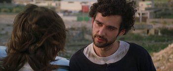 Movie still from “Paradise Now” (2005), directed by Hany Abu-Assad – A man with curly hair talking to another man; Close Up shot, Over the shoulder angle