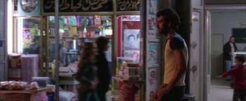 Movie still from “Paradise Now” (2005), directed by Hany Abu-Assad – A man standing in front of a newspaper store; Wide shot, Over the shoulder angle