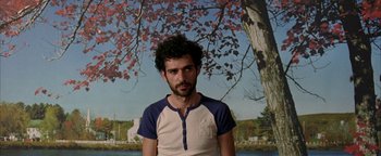 Movie still from “Paradise Now” (2005), directed by Hany Abu-Assad – A man standing in front of a painting of a tree; Medium shot, Low angle