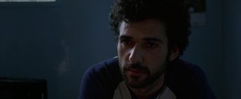Movie still from “Paradise Now” (2005), directed by Hany Abu-Assad – A person with a beard looking at the camera; Close Up shot, Over the shoulder angle