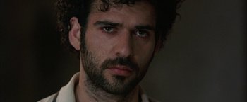Movie still from “Paradise Now” (2005), directed by Hany Abu-Assad – A person with a beard looking at the camera; Close Up shot, Low angle