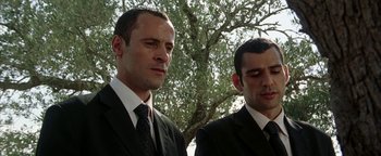 Movie still from “Paradise Now” (2005), directed by Hany Abu-Assad – A couple of men standing next to each other in suits; Close Up shot, Low angle
