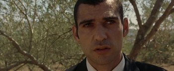 Movie still from “Paradise Now” (2005), directed by Hany Abu-Assad – A person wearing a suit and tie; Close Up shot, Low angle