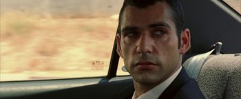 Movie still from “Paradise Now” (2005), directed by Hany Abu-Assad – A person wearing a suit in a car; Close Up shot, Over the shoulder angle
