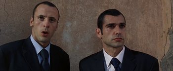 Movie still from “Paradise Now” (2005), directed by Hany Abu-Assad – Two men in suits and ties standing next to each other; Close Up shot, Low angle