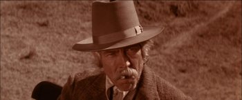 Movie still from “Pat Garrett & Billy the Kid” (1973), directed by Sam Peckinpah – An old man with a hat and a mustache; Close Up shot, Low angle