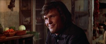 Movie still from “Pat Garrett & Billy the Kid” (1973), directed by Sam Peckinpah – A person with long hair wearing a shirt and bow tie; Close Up shot, Low angle