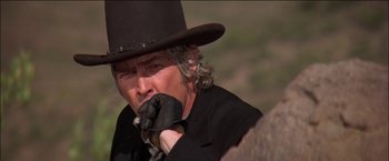 Movie still from “Pat Garrett & Billy the Kid” (1973), directed by Sam Peckinpah – A man in a black hat and a black jacket; Close Up shot, Low angle
