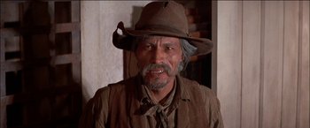 Movie still from “Pat Garrett & Billy the Kid” (1973), directed by Sam Peckinpah – An older man wearing a cowboy hat in a room; Close Up shot, Low angle