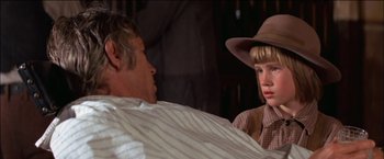 Movie still from “Pat Garrett & Billy the Kid” (1973), directed by Sam Peckinpah – A man and a boy in a room; Close Up shot, Over the shoulder angle