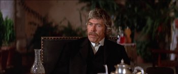 Movie still from “Pat Garrett & Billy the Kid” (1973), directed by Sam Peckinpah – An older man sitting in a chair in a room; Close Up shot, Low angle