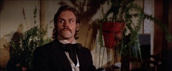 Movie still from “Pat Garrett & Billy the Kid” (1973), directed by Sam Peckinpah – A person wearing a suit and a bow tie; Close Up shot, Low angle