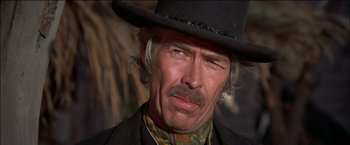 Movie still from “Pat Garrett & Billy the Kid” (1973), directed by Sam Peckinpah – A man with a mustache wearing a black hat; Close Up shot, Low angle