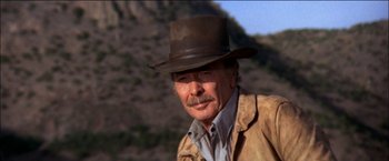 Movie still from “Pat Garrett & Billy the Kid” (1973), directed by Sam Peckinpah – An older man wearing a brown hat and a brown jacket; Close Up shot, Low angle
