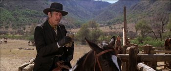 Movie still from “Pat Garrett & Billy the Kid” (1973), directed by Sam Peckinpah – A man sitting on top of a horse in a field; Medium shot, Low angle