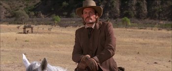 Movie still from “Pat Garrett & Billy the Kid” (1973), directed by Sam Peckinpah – A man in a suit and hat sitting on a horse; Medium shot, Low angle