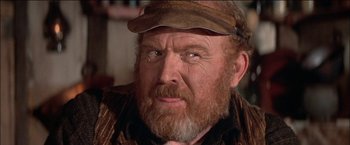 Movie still from “Pat Garrett & Billy the Kid” (1973), directed by Sam Peckinpah – An older man with a beard and a hat; Close Up shot, Over the shoulder angle