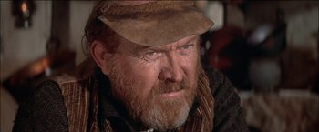 Movie still from “Pat Garrett & Billy the Kid” (1973), directed by Sam Peckinpah – An older man with a beard and a hat; Close Up shot, Over the shoulder angle