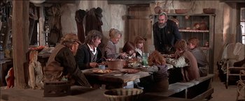Movie still from “Pat Garrett & Billy the Kid” (1973), directed by Sam Peckinpah – A group of people sitting around a table eating food; Medium shot, High angle