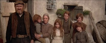 Movie still from “Pat Garrett & Billy the Kid” (1973), directed by Sam Peckinpah – A group of people standing next to each other near a building; Medium shot, Low angle