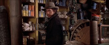 Movie still from “Pat Garrett & Billy the Kid” (1973), directed by Sam Peckinpah – A man wearing a hat standing in a room filled with pots and pans; Medium shot, Low angle