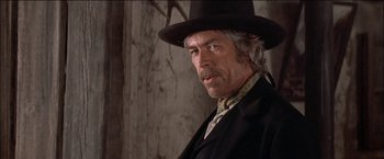 Movie still from “Pat Garrett & Billy the Kid” (1973), directed by Sam Peckinpah – An older man wearing a black hat and a black coat; Close Up shot, Low angle