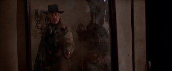 Movie still from “Pat Garrett & Billy the Kid” (1973), directed by Sam Peckinpah – An old man wearing a hat and a coat is standing in front of a mirror; Medium shot, Low angle