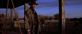 Movie still from “Pat Garrett & Billy the Kid” (1973), directed by Sam Peckinpah – An older man in a hat and a trench coat; Medium shot, Low angle