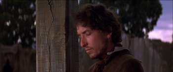 Movie still from “Pat Garrett & Billy the Kid” (1973), directed by Sam Peckinpah – A person with his eyes closed; Close Up shot, Over the shoulder angle