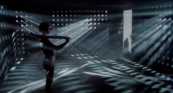 Movie still from “Patty Hearst” (1988), directed by Paul Schrader – A woman holding a baseball bat while standing in a dark room; Wide shot, Low angle