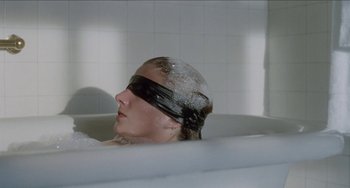 Movie still from “Patty Hearst” (1988), directed by Paul Schrader – A woman with a blindfold is in a bath tub; Close Up shot, High angle