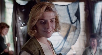 Movie still from “Patty Hearst” (1988), directed by Paul Schrader – A person with blonde hair smiling; Close Up shot, Low angle