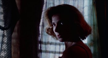 Movie still from “Patty Hearst” (1988), directed by Paul Schrader – A woman is looking out of a window at night; Close Up shot, Low angle
