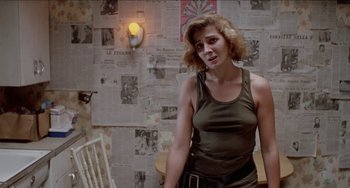 Movie still from “Patty Hearst” (1988), directed by Paul Schrader – A woman standing in front of a wall covered with papers; Medium shot, Over the shoulder angle