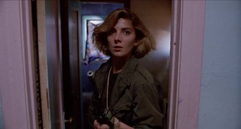 Movie still from “Patty Hearst” (1988), directed by Paul Schrader – A woman holding a camera in a room; Close Up shot, Low angle