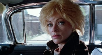Movie still from “Patty Hearst” (1988), directed by Paul Schrader – A person in a car looking at the camera; Close Up shot, Low angle