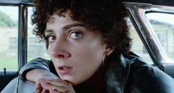 Movie still from “Patty Hearst” (1988), directed by Paul Schrader – A person with a black jacket; Close Up shot, Low angle