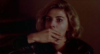 Movie still from “Patty Hearst” (1988), directed by Paul Schrader – A woman with her hands over her mouth; Close Up shot, Low angle