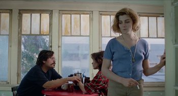 Movie still from “Patty Hearst” (1988), directed by Paul Schrader – A man and a woman standing in front of another woman in front of another man; Medium shot, Over the shoulder angle