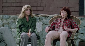 Movie still from “Patty Hearst” (1988), directed by Paul Schrader – Two women sitting on a chair in front of a wall; Medium shot, High angle