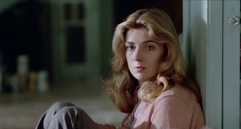 Movie still from “Patty Hearst” (1988), directed by Paul Schrader – A woman sitting on the ground in front of a window; Close Up shot, Low angle