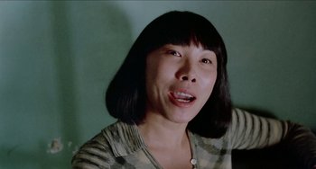 Movie still from “Patty Hearst” (1988), directed by Paul Schrader – A person with short black hair; Close Up shot, Low angle