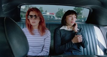 Movie still from “Patty Hearst” (1988), directed by Paul Schrader – Two women sitting in the back seat of a car; Medium shot, Low angle