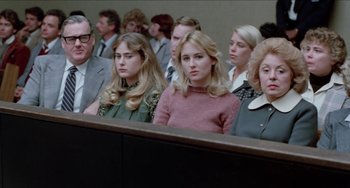 Movie still from “Patty Hearst” (1988), directed by Paul Schrader – A group of people sitting in front of a judge; Medium shot, Over the shoulder angle
